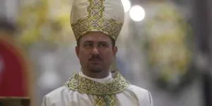 Dom Paolo Andreolli vestido com roupas clericais brancas de bispo e olhando para o povo durante uma Santa Missa